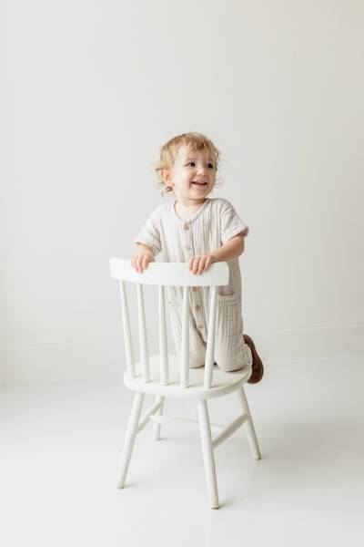 photo petit garçon a genoux sur une chaise
