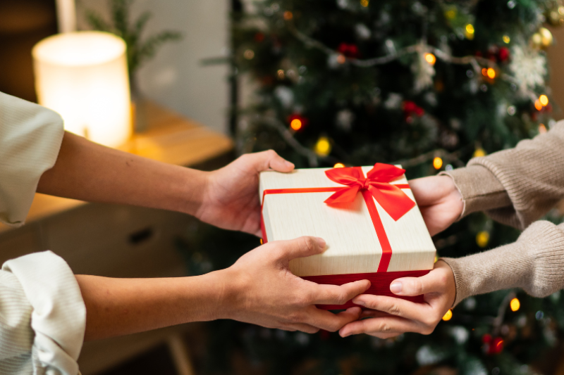 femme qui offre un cadeau à Noel 